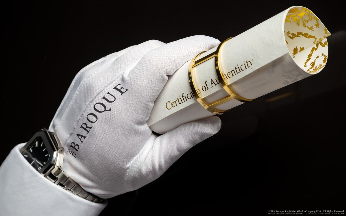 Gloved hand and fine watch holding the rolled Baroque Whisky Certificate of Authenticity, on black
