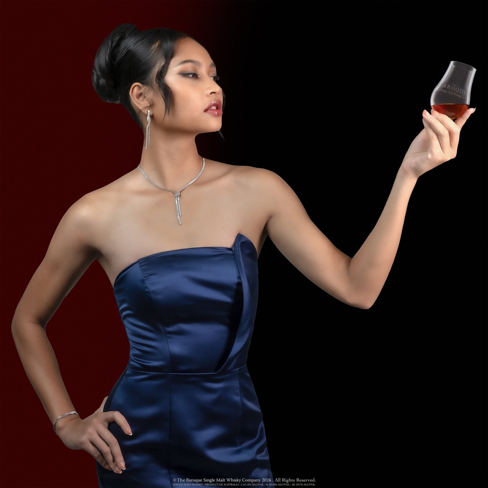 Model presenting a glass of Baroque Single Malt Whisky against a red gradient