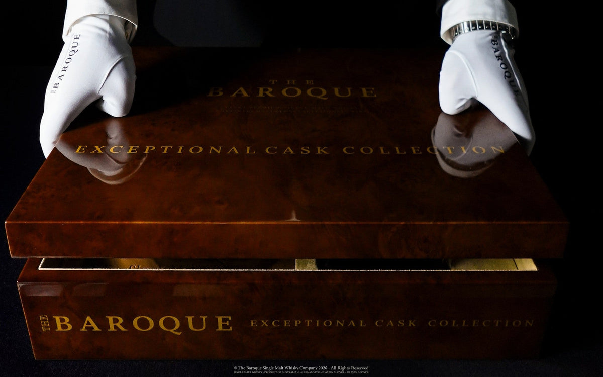 White gloved hands resting on the closed Baroque Exceptional Cask Collection case, landscape crop