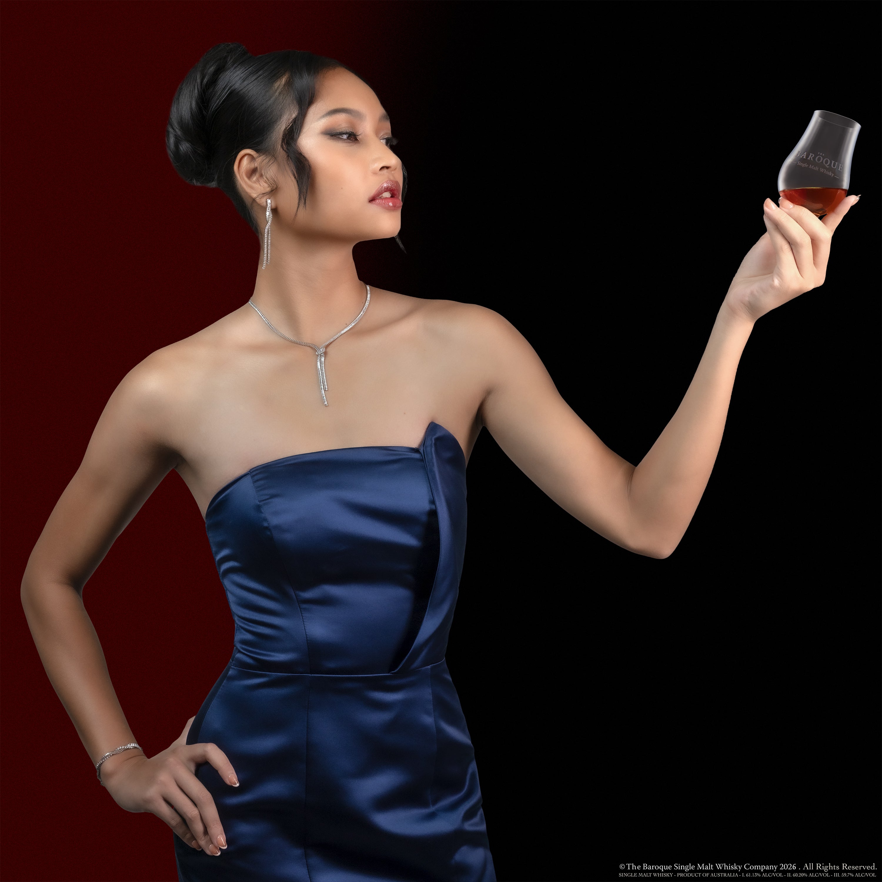 Model raising a Baroque Glencairn nosing glass against a deep red gradient