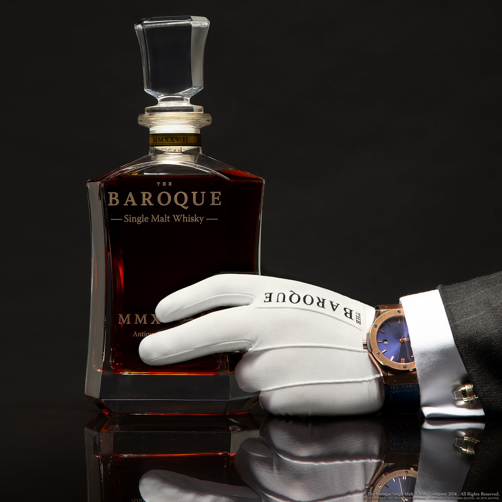 White gloved hand with fine watch resting on the Baroque MMXXV Edition II decanter, Antique Tawny Cask